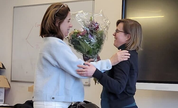 Liesbeth Kranenburg geeft Martine van der Pluim een bos bloemen