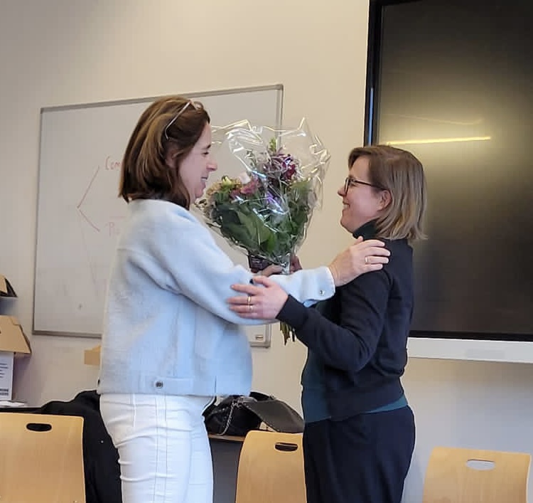 Liesbeth Kranenburg geeft Martine van der Pluim een bos bloemen